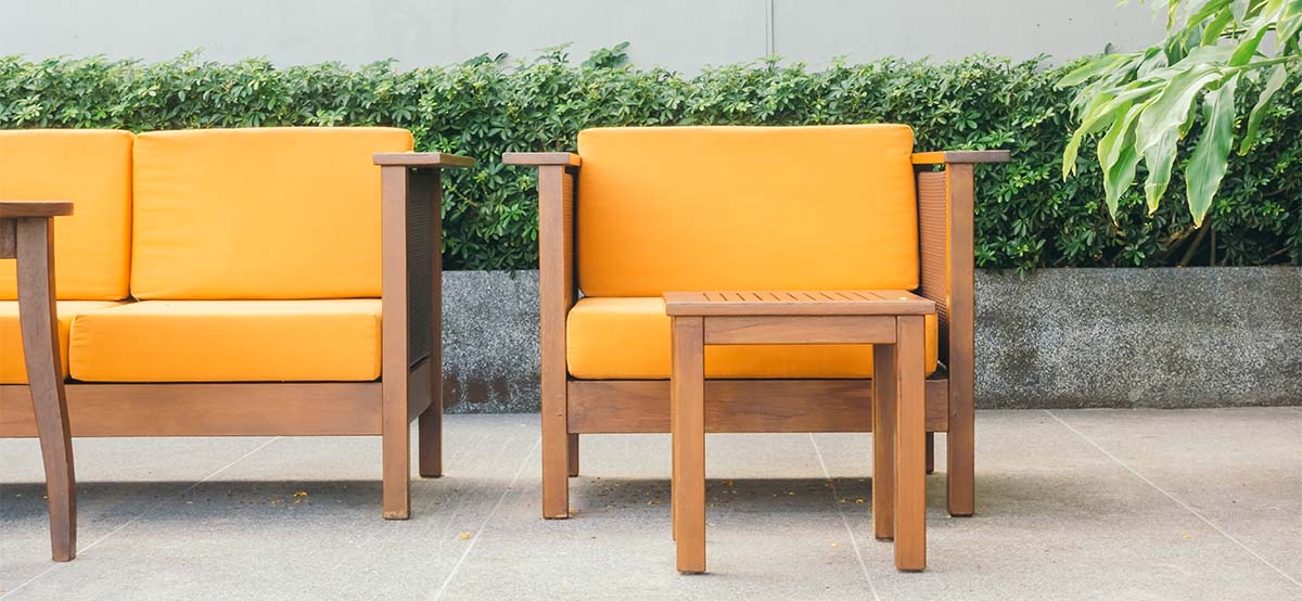 modern outdoor seating with bushes in the back